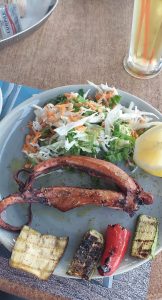 a plate of food with a lemon wedge and vegetables